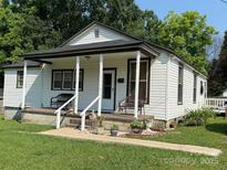 Charming home with a covered front porch, benches, and landscaped garden at 714 E Dunlap St, Lancaster, SC 29720