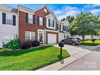 Charming townhome featuring a brick facade, well-maintained lawn, and a one-car garage at 8002 Mariners Pointe Cir, Denver, NC 28037