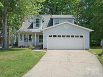 Charming two-story home features a large garage, landscaped front yard, and welcoming front porch at 8030 Glencannon Dr, Charlotte, NC 28227