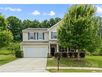 Beautiful home exterior featuring a manicured lawn, mature tree, and two-car garage at 8400 Empress Ct, Charlotte, NC 28227