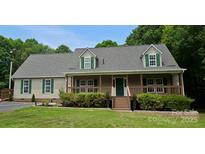 Charming home with a covered front porch, green shutters, and well-manicured landscaping at 8632 Island Point Rd, Sherrills Ford, NC 28673