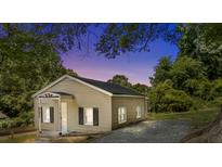 Charming single-story home with neutral siding, black shutters, complemented by lush greenery at 103 Garfield Ave, Albemarle, NC 28001