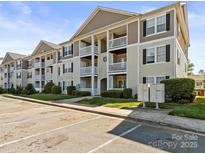 Spacious condo building with multiple floors, balconies, and ample parking spaces in a well-maintained community at 1104 Plaza Walk Dr, Charlotte, NC 28215