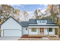 Charming modern farmhouse with a covered porch, attached garage, and clean white siding at 129 John Smith Rd, York, SC 29745