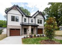 Charming two-story home featuring a brick and white facade, a landscaped front yard, and a two-car garage at 1728 Dallas Ave, Charlotte, NC 28205