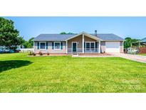 Charming single-story home featuring a well-manicured lawn, cozy front porch, and attached garage at 2031 36Th Ne St, Hickory, NC 28601