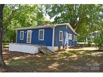 Charming blue home with white trim, porch, and mature trees surrounding the property at 2131 E Nc 10 Hwy, Conover, NC 28613