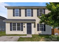 Charming two-story home featuring light yellow siding, black shutters, and a well-maintained front yard at 3527 Crestridge Dr, Charlotte, NC 28217