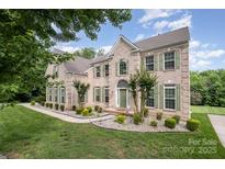 Stunning two-story brick home featuring a manicured lawn and complemented by lush, mature trees at 4201 Amber Leigh Way Dr, Charlotte, NC 28269