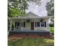 Charming home featuring a cozy front porch with a swing and hanging plants at 4421 Linwood Rd, Gastonia, NC 28052