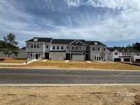 Newly constructed townhomes with attached garages, neutral color scheme, and freshly laid sod at 502 Webster Ln, Cramerton, NC 28032