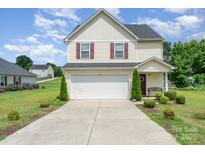 Charming two-story home with a well-maintained lawn, a two-car garage, and nicely manicured landscaping at 635 Scarlet Leaf Ln, Oakboro, NC 28129