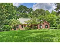 Charming brick home with well-manicured lawn and mature trees offering a serene setting at 7117 Cobblecreek Dr, Weddington, NC 28104