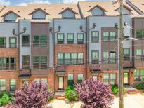 A modern townhome with gray siding, a brick facade, and manicured landscaping at 819 Anderson St, Charlotte, NC 28205