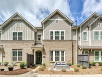 Charming brick townhome with a cozy front patio seating area and well-manicured landscaping at 10022 Wayfair Meadow Ct, Charlotte, NC 28277