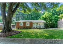 Charming brick home featuring a manicured lawn and covered porch with seating at 106 Valley Rd, York, SC 29745