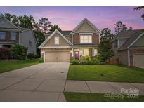 Charming two-story home with a well-manicured lawn, stone accents, and a two-car garage at 11070 River Oaks Nw Dr, Concord, NC 28027