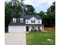 Charming two-story home with well-manicured lawn, covered porch, and attached two-car garage at 12150 Plover Dr, Charlotte, NC 28269