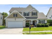 Charming two-story home featuring a well-manicured lawn, attached garage, and inviting front porch at 12312 Mcallister Park Dr, Charlotte, NC 28277