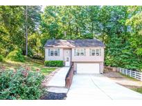 Charming two-story home with a well-manicured lawn, attached garage, and inviting front entrance surrounded by mature trees at 125 Shenandoah Loop, Troutman, NC 28166