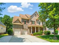 Beautiful two-story home featuring a two-car garage, charming front porch, and meticulously landscaped yard at 129 N Audubon Ave, Mooresville, NC 28117