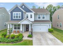 Charming two-story home featuring a covered front porch, two-car garage, and beautifully landscaped front yard at 14734 Rivergate Pkwy, Charlotte, NC 28273