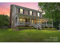 Charming two-story home with a covered front porch, landscaped yard, and beautiful curb appeal at 1543 Newfound Hollow Dr, Charlotte, NC 28214