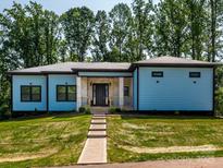 Beautiful blue home with a well-manicured lawn and large trees in the background at 2004 Plain Field Dr, Bessemer City, NC 28016