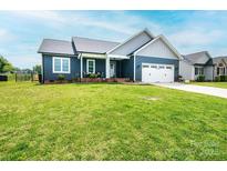 Beautiful one story home featuring navy siding, a two car garage, and a lush green lawn at 201 S 5Th Ave, Maiden, NC 28650
