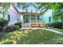 Charming two-story home with a covered front porch, manicured lawn and landscaped garden at 228 Coneflower Pl, Fort Mill, SC 29708