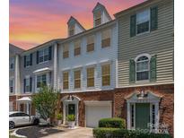 Charming townhome with brick and siding exterior with a warm sunset in the background at 2945 Duvalla Ave, Charlotte, NC 28209