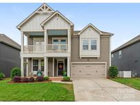 Charming two-story home featuring a covered porch, attached garage, and well-maintained lawn at 4305 Twenty Grand Dr, Indian Trail, NC 28079