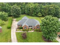 Stunning aerial view of a brick home surrounded by lush greenery and a well-manicured lawn at 5410 Berryview Ln, Gastonia, NC 28056