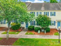 Inviting townhome with charming curb appeal, featuring a landscaped front yard and blue shutters at 5623 Fetzer Nw Ave, Concord, NC 28027