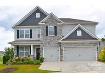 Charming two-story home with stone accents, well-maintained landscaping, and a spacious two car garage at 7046 North Bridge Dr, Huntersville, NC 28078
