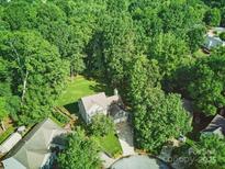 Lush aerial view of a house nestled among mature trees, showcasing its serene setting and green surroundings at 7344 Maitland Ln, Charlotte, NC 28215