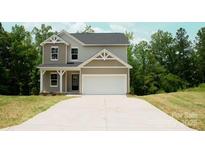 Charming two-story home features a two-car garage and neutral siding, set against a backdrop of lush trees at 7601 Hammond Dr, Charlotte, NC 28215