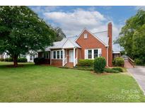 Charming brick home featuring a well-manicured lawn, bright white trim, and a classic brick chimney at 761 Milton Ave, Rock Hill, SC 29730