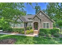 Charming home featuring stone facade, inviting front porch and professionally landscaped front yard at 7916 Deerbridge St, Mint Hill, NC 28227