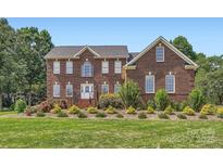 Charming two-story brick home featuring a well-manicured lawn and lush landscaping at 1185 Willow Creek Dr, Newton, NC 28658