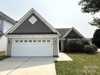 Charming home featuring a two-car garage, well-manicured lawn and mature landscaping at 1423 Napa Nw St, Concord, NC 28027