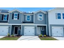 Charming townhome features a one car garage, craftsman style doors and a beautiful blue exterior at 1423 Old Rivers Rd, Concord, NC 28027