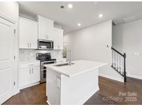 Bright kitchen features an island, stainless steel appliances and white cabinets at 1433 Old Rivers Rd, Concord, NC 28027
