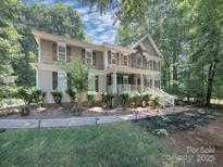 Charming two-story home with a landscaped yard and a mix of stone and beige siding at 155 Culpeze Rd, Mooresville, NC 28117