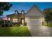 Charming two-story home boasts a manicured lawn, stone accents, and an attached two-car garage at 196 Sutters Mill Dr, Troutman, NC 28166