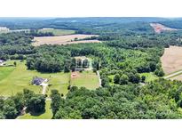 Sprawling property showcasing a home, pond, fields, and lush woodlands in a picturesque aerial shot at 2932 Rant Drum Rd, Maiden, NC 28650