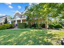 Charming two-story home boasts a lush green lawn, stone accents, and mature trees at 4009 Oxford Mill Rd, Waxhaw, NC 28173