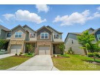 Inviting two-story townhome featuring a one-car garage, brick accents, and landscaped front yard at 5334 Orchid Bloom Dr, Fort Mill, SC 29707