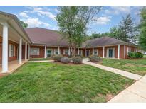 Charming brick home featuring manicured lawn and sidewalk leading to the entrance at 7012 Somerset Springs Dr # E, Charlotte, NC 28262