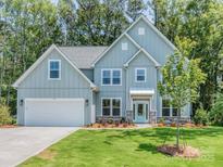 Charming two-story home with a light blue exterior, well-manicured lawn, and an attached two-car garage at 7108 Hambright Rd, Huntersville, NC 28078